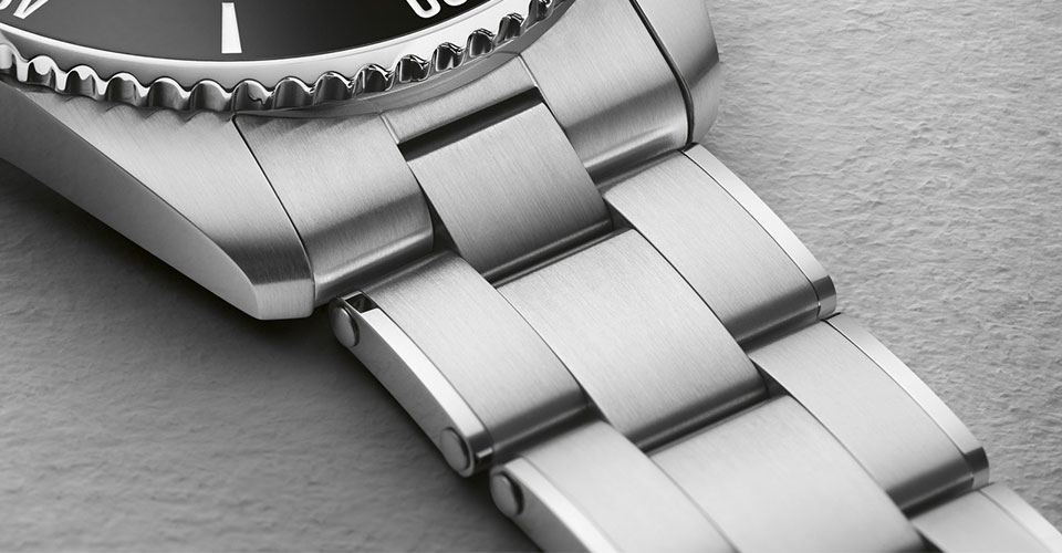 ダイバーズウォッチの大切な要素であるメタルブレスレットはコマをリベットで繋ぐ薄型で重すぎない着け心地です。全体がヘアライン仕上げでありながら、サイドにポリッシュをと入れることで存在感が感じられます。