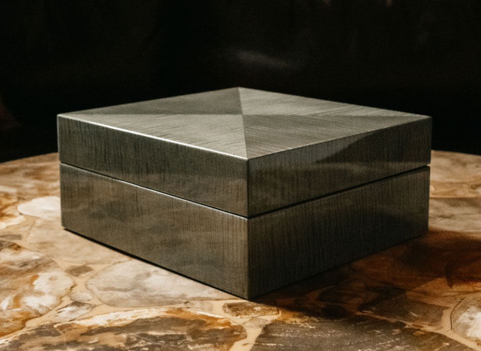 MDF材をコアに用い、そこに美しい杢を持つ、さまざまな銘木の突板を貼り付けた「松創」の時計ケース。こちらのモデルでは虎目状の杢が素晴らしいシカモア材を用い、それを貼り付ける方向をアレンジすることで比類のない美しさと独特の存在感を獲得している。