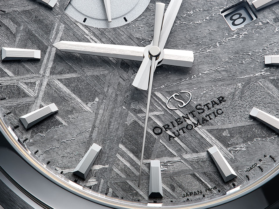 もともとは星のコアであり、地球上で知られる隕石の中では最古とされるムオニオナルスタ隕石を文字盤に使用。数百万年をかけて形成されたウィドマンシュテッテン構造と呼ばれる結晶模様は、文字盤の原料によってパターンが異なるため、世界にひとつだけの表情が楽しめるのも、このモデルの魅力だ。