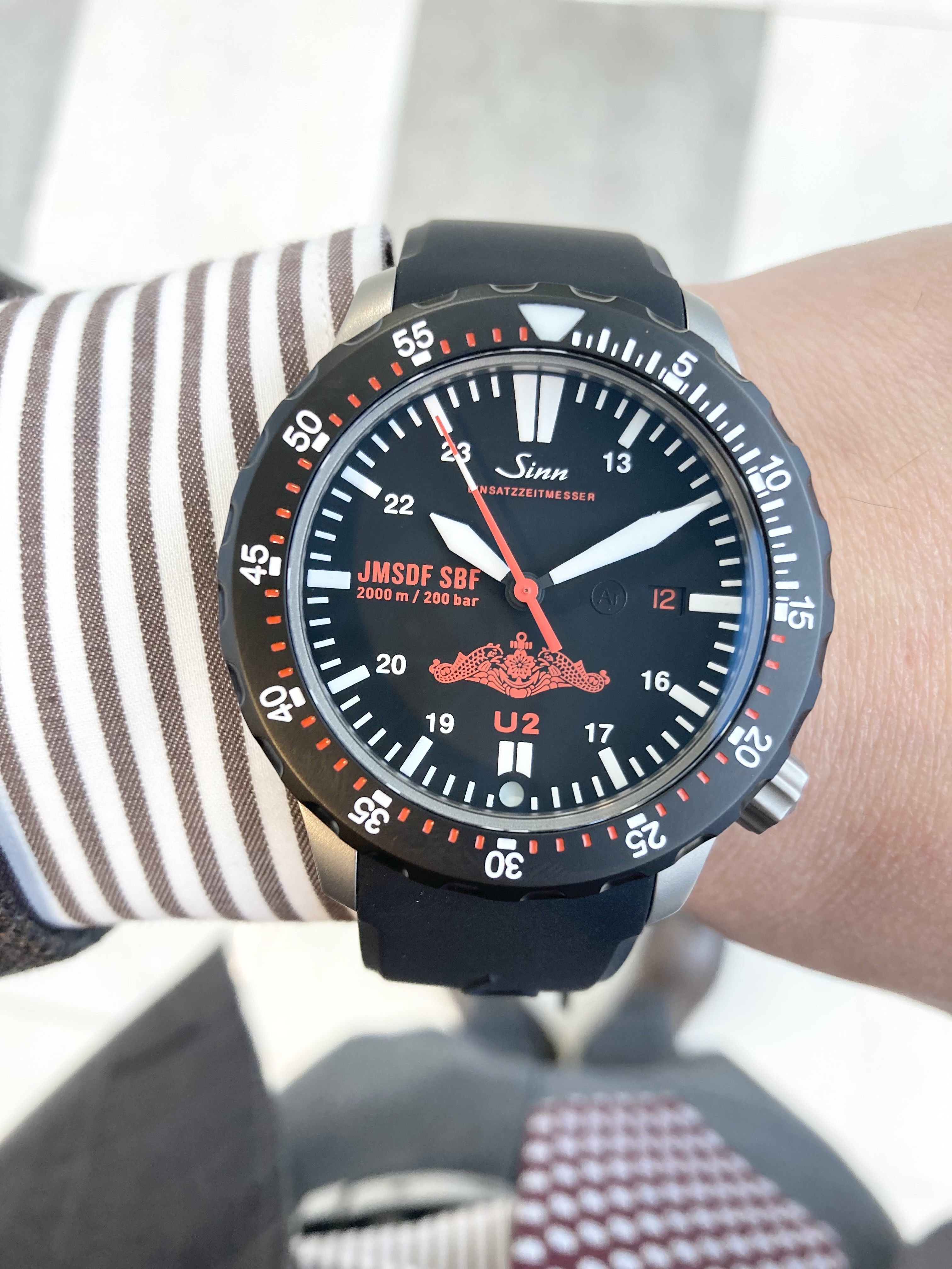 <br />
SINN<br />
品番 U2.J-SBF R<br />
【日本限定50本】U2.J-SBF<br />
¥528,000(税込)<br />
<br />
このモデルは、2,000mの防水性を備えたジンのU2.SDRをベースに、<br />
海上自衛隊潜水艦隊の任務に従事する隊員たちに向けて開発した、<br />
ハイスペックな機械式腕時計です。<br />
<br />
より視認性を高めるために、<br />
ベースモデルに搭載されていた第二時間帯を外し、<br />
インデックスに13時から24時までの目盛りを追加して午後の時間帯表示を備えました。<br />
<br />
最大の特徴はダイヤルの6時位置に配された潜水艦隊のドルフィンマークです。<br />
<br />
さらに9時位置には海上自衛隊と潜水艦隊の<br />
略号JMSDF(Japan Maritime Self-Defense Force)<br />
およびSBF(Fleet Submarine Force)が印されています。<br />
<br />
これらの印とモデル名を表す「U2」という文字、<br />
日付表示などの黒を背景にした赤い色は、<br />
深い海に潜った際に目立たない配色であり、<br />
ダイビングに必要な部分だけに白い夜光処理が施された、機能的なデザインです。<br />
<br />
ドイツ最新鋭潜水艦の鋼鉄であるUボート・スチールや<br />
テギメント加工された特殊結合方式の回転ベゼル、<br />
Arドライテクノロジーといったジン・テクノロジーもベースモデル同様です。<br />
<br />
「U2.J-SBF」は、ダイバーズウォッチとしての用途を考慮し、<br />
ジンの持つ独創的なテクノロジーを満載した過酷なミッションにも最適なプロフェッショナルダイバーズウォッチです。<br />
<br />
希少なモデルです。<br />
<br />
気になる方はお早めに!