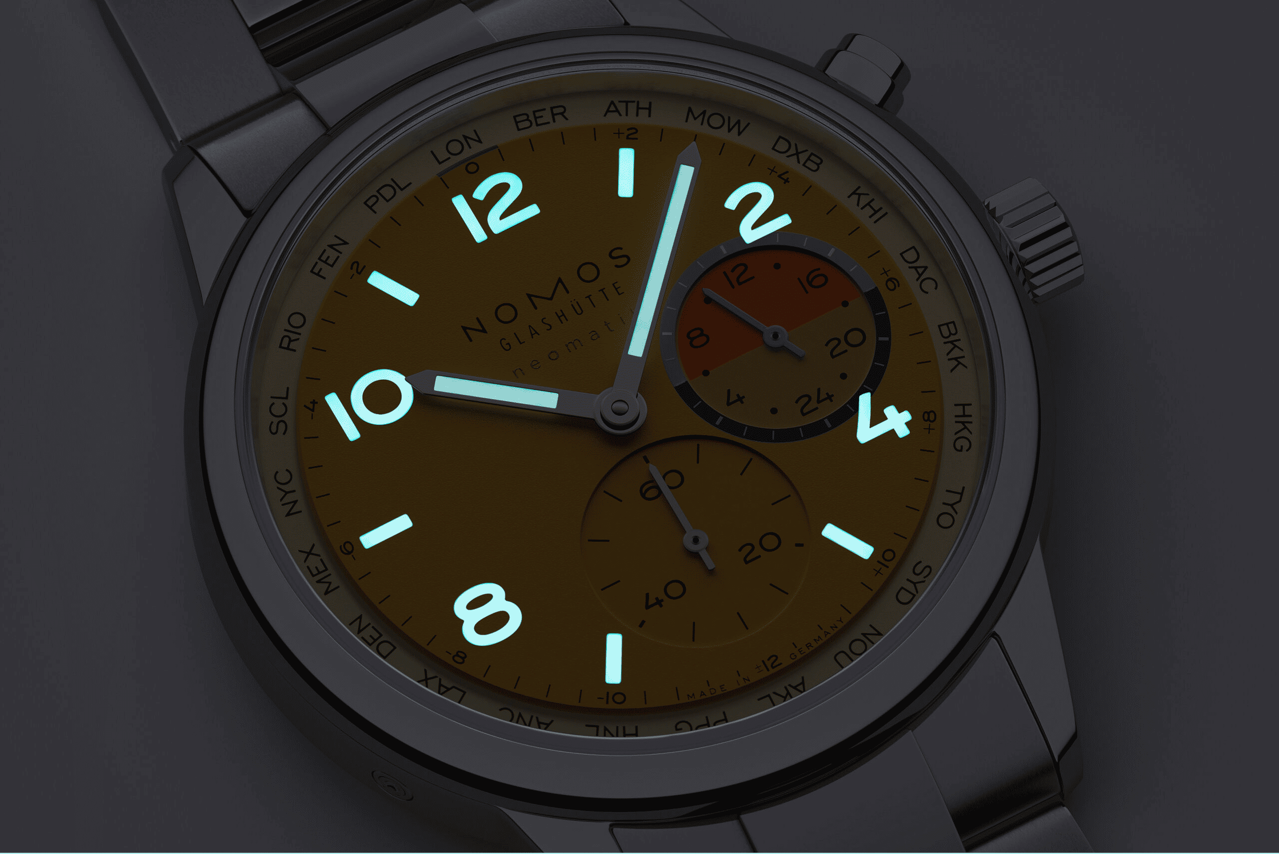 NOMOS GLASHÜTTE  クラブ・スポーツ ネオマティック ワールドタイマー デューン　NM790.S6弾力や回復力に色があるとすれば、この腕時計の黄金のベージュ色はその最高の選択肢となるでしょう。果てしなき地平線と不変に見える変化に満ちた砂漠を彷彿とさせるからです。そして、ダイアル上では2つの冷たいブルーのセミサークルが温かい夕日のオレンジを蜃気楼のように捉えています。 自動巻きキャリバーを搭載するこのワールドタイム機能付き腕時計においては、スポーティーさと機能性が均衡しており、一目で24のタイムゾーンを見ることができ、セカンドタイムゾーンの24時間表示も備わっています。デューンは175本限定であり、世界との特別な自分だけの繋がりをもたらします。