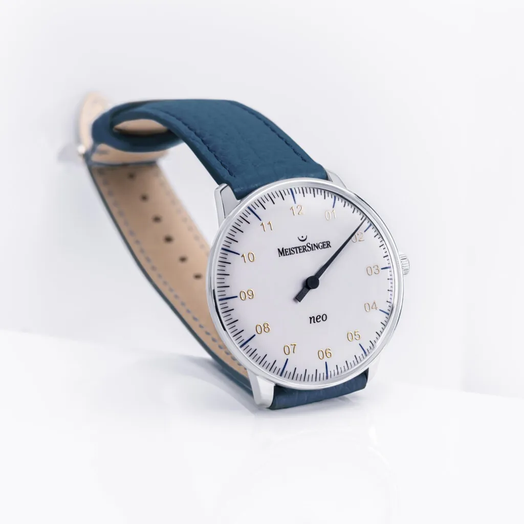 MeisterSinger Neo NES901Gは、1960年代のデザイン美学にインスパイアされたミニマルな自動巻き腕時計で、ドーム型サファイアクリスタル風防と36mmのスリムなケースが特徴。ベゼルレスで滑らかなシルエットが際立ち、男女問わず手元にフィットするユニセックス仕様。プレゼントとしても最適な、機械式シングルハンドの名作。