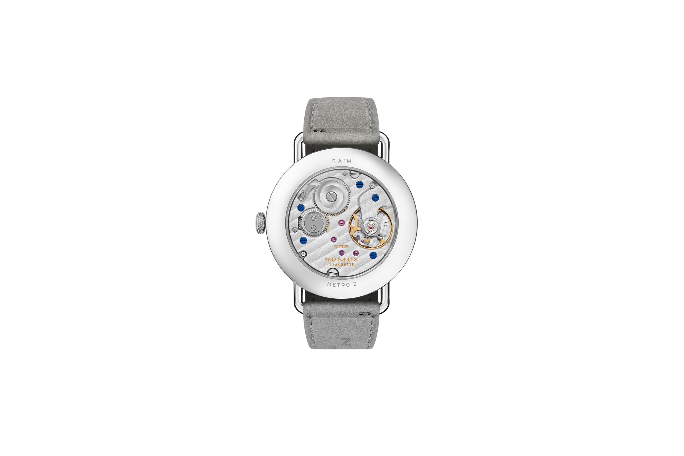 NOMOS Glashütte / METRO 33 / NM1124スタイリッシュなメトロの10周年に向けて、フェミニンなサイズ33のSSケースがファミリーに加わります。  大都会をイメージしたメトロ33は輝くガラス張りのビル（オールシルバー）・ブルックリンによくみられる赤煉瓦の建物（ミュートレッド）・公園や自由の女神の心豊かな緑（セージ）の3色です。  複雑なダブルカーブのサファイアクリスタルガラス、繊細なワイヤーラグ、また時計師が使う道具をモチーフにした特徴的なメトロリューズなど、すべてが非の打ちどころのないグラスヒュッテのクラフツマンシップと最高基準のデザインです。  時計のデザインを引き締めているのはライトグレーのヴィーガンベロアストラップ。スマートで遊び心があり、エネルギーに満ちている現代的なエレガンスを表現している3種類のメトロは、女性でだけでなくもちろんスレンダーな腕周りの男性にも似合います。