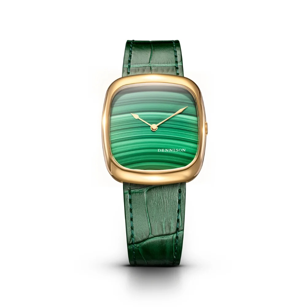 Natural Malachite Stone In Gold ALD-G-ST01-GRN-R-GBKL ダイヤルには天然マラカイト（孔雀石）を採用。深みのあるグリーンの縞模様と豊かな階調は、一点一点異なる表情を見せ、天然石ならではの存在感を際立たせます。丁寧にカット・ポリッシュされたストーンダイヤルは、控えめながらも確かな主張を放ちます。 ケースはゴールドPVD仕上げのステンレススチール製。37mm × 33.5mm、厚さ約6.05mmのスリムなプロポーションで、ドレススタイルにも自然に馴染みます。型押しのグリーンレザーストラップと、ケースの曲線美を反映した特別仕様のピンバックルが、全体の完成度をさらに高めています。 時代を超えて愛されるスタイルと、繊細なディテールへのこだわりを体現した1本です。