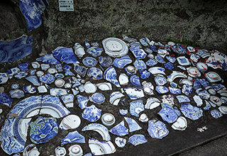 有田の歴史を物語る幕末から大正にかけて登り窯で焼かれた磁器片が工房脇に埋め込まれている。かけらとはいえ、見事な筆さばきと美しい呉須（青い顔料）の発色に魅了される