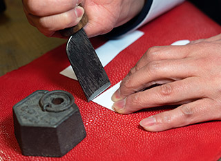 ガルーシャの革に型紙を当てて革包丁で切り出す。“石”と呼ばれる硬い組織を持つガルーシャ革は刃物にも負担がかかる